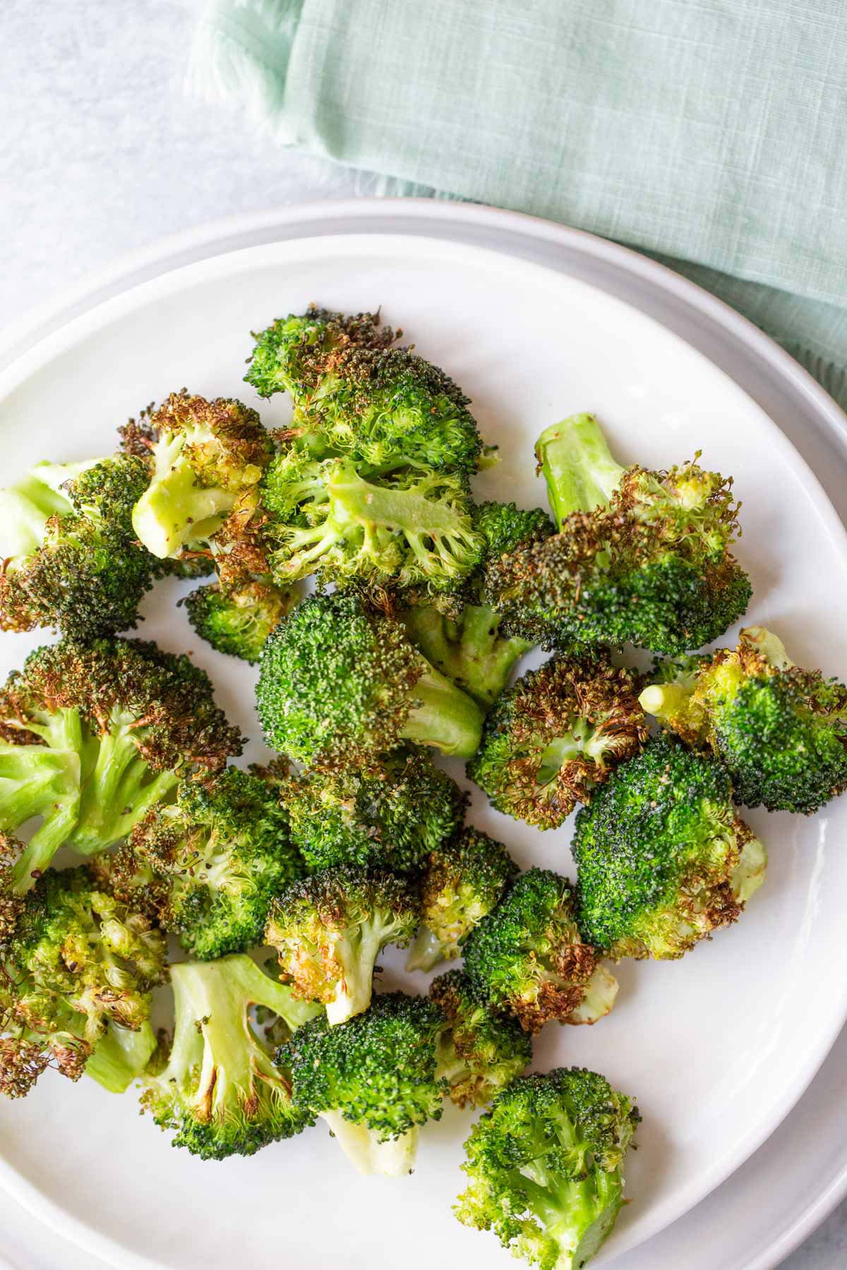 Air fried broccoli on a white plate