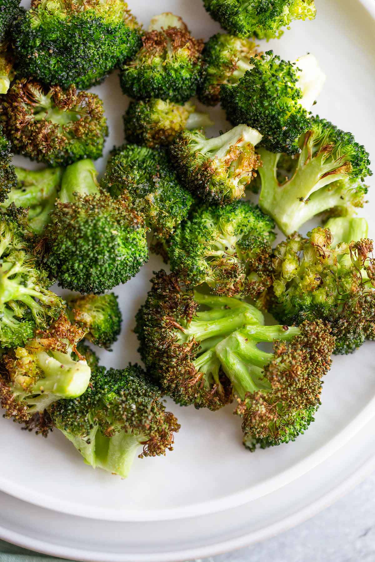 Air fried broccoli on a white plate