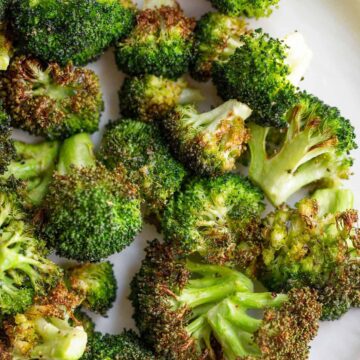 Air fried broccoli on a white plate