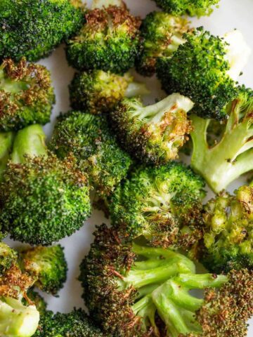 Air fried broccoli on a white plate