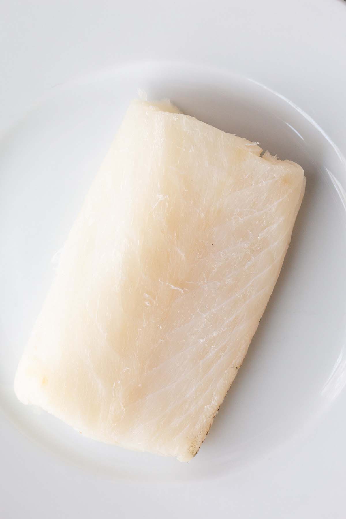 Raw cod on a white plate