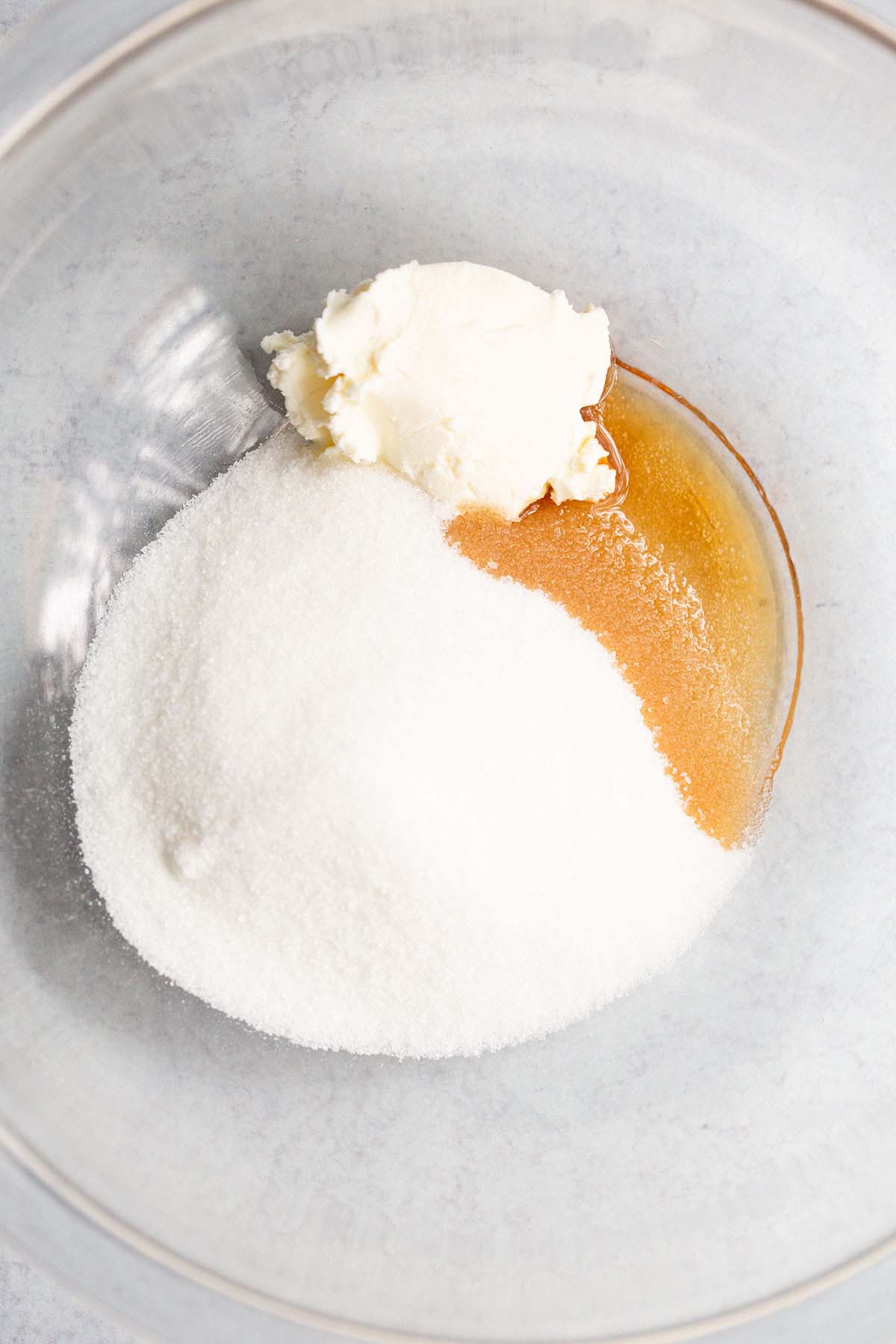 Cream cheese, vanilla, and sugar in a bowl.