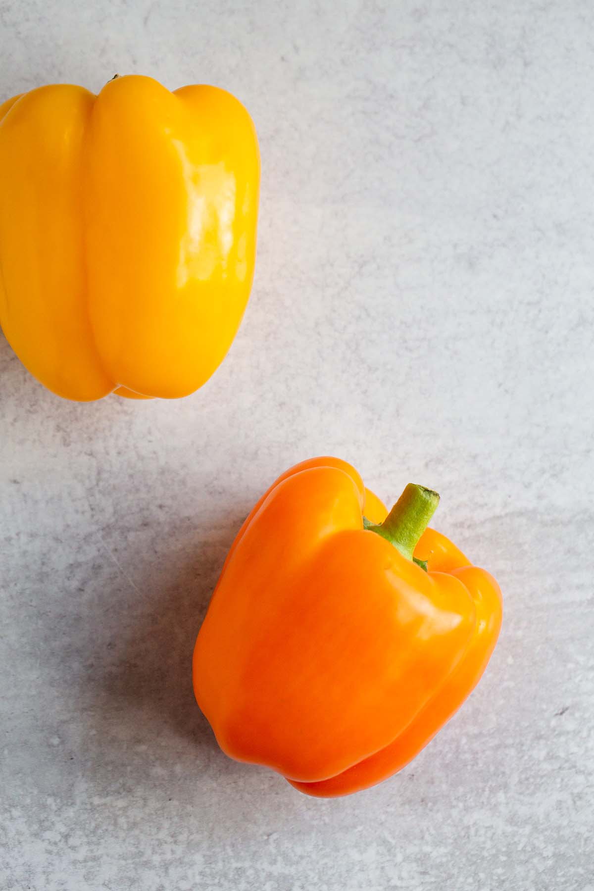 2 raw bell peppers - an orange one and a yellow one