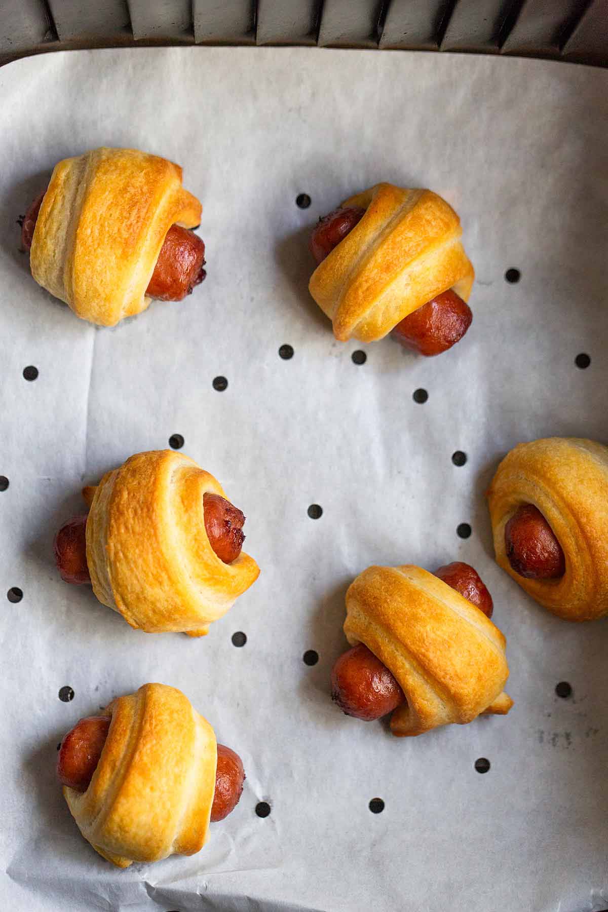 Pigs in a blanket in air fryer basket.