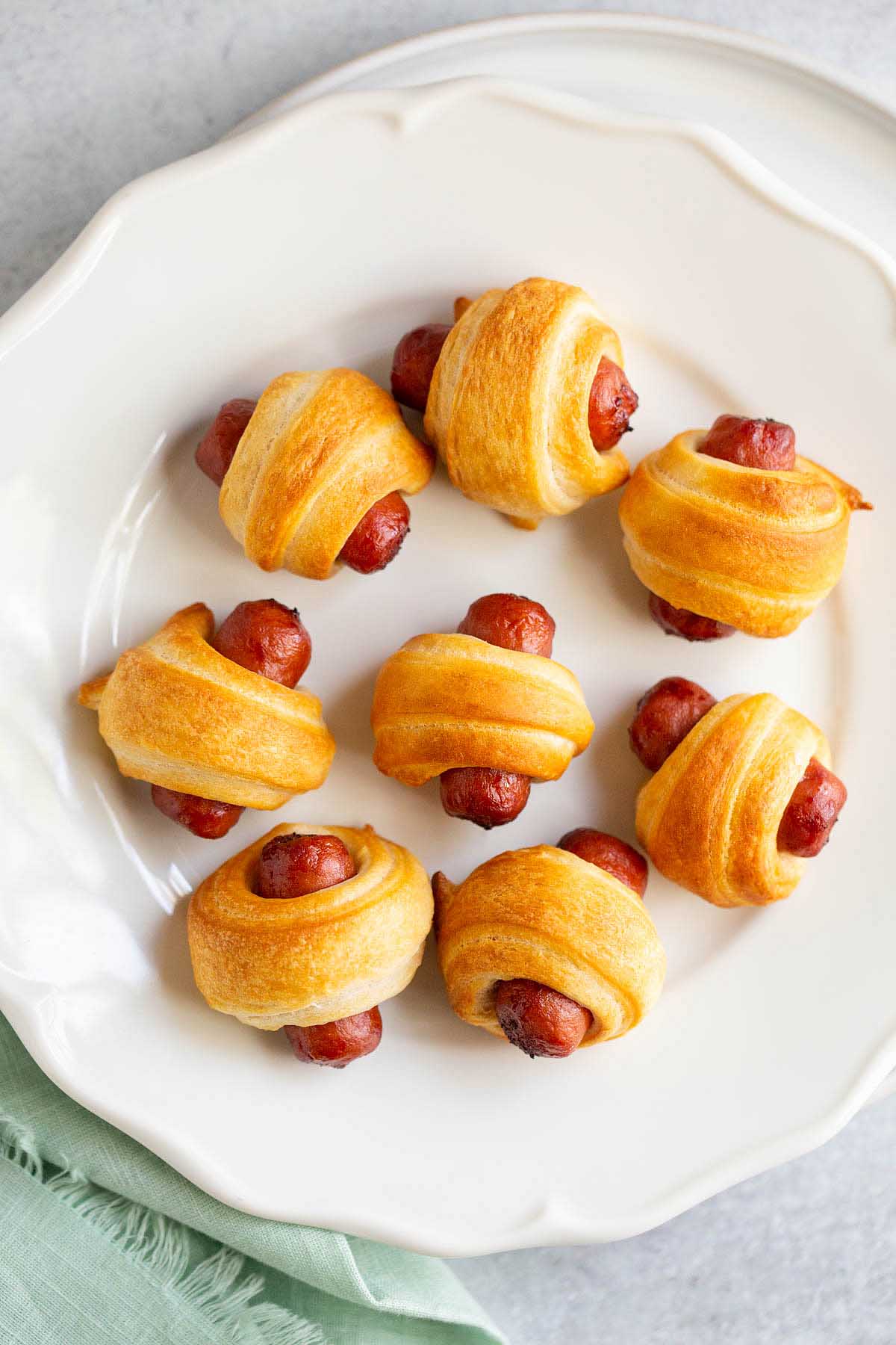 Air fried pigs in a blanket on a white plate.