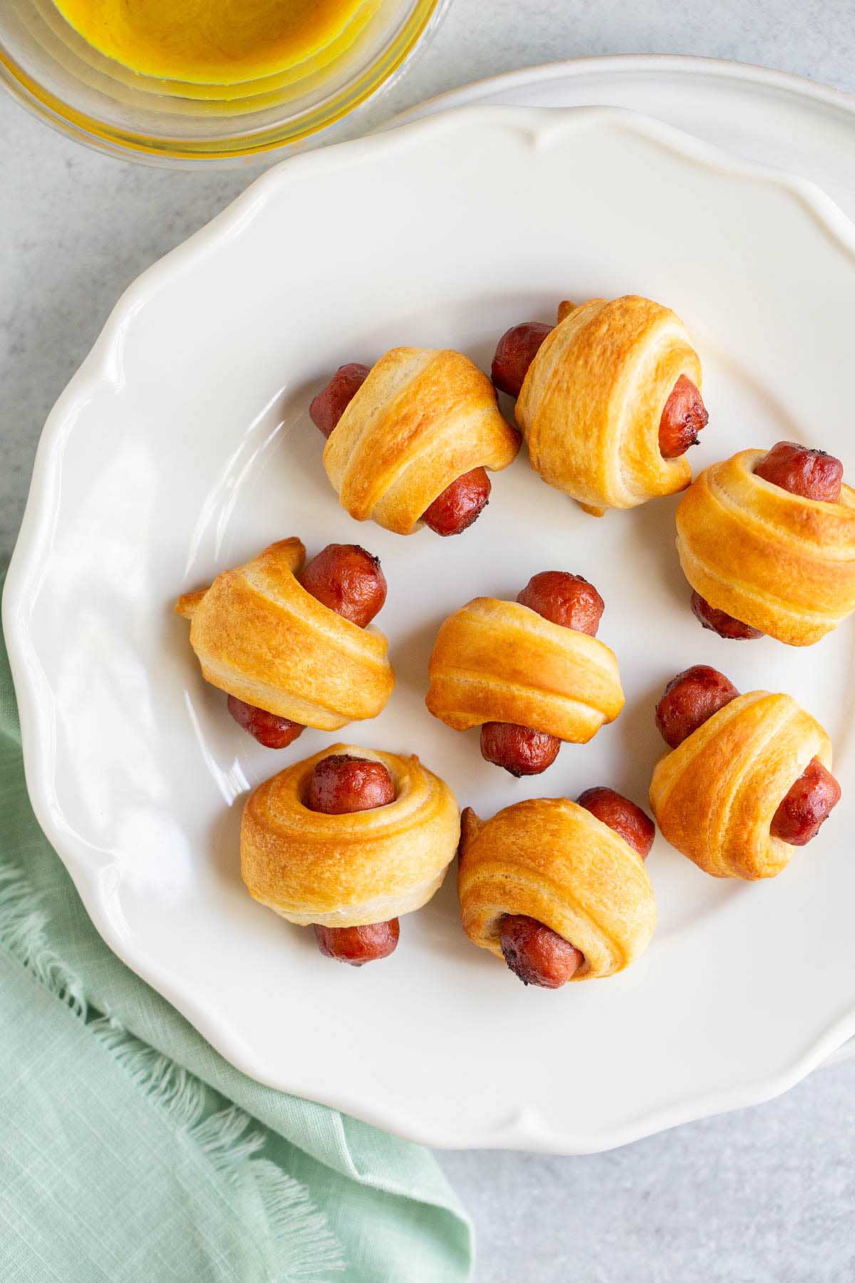 Air fried pigs in a blanket on a white plate.