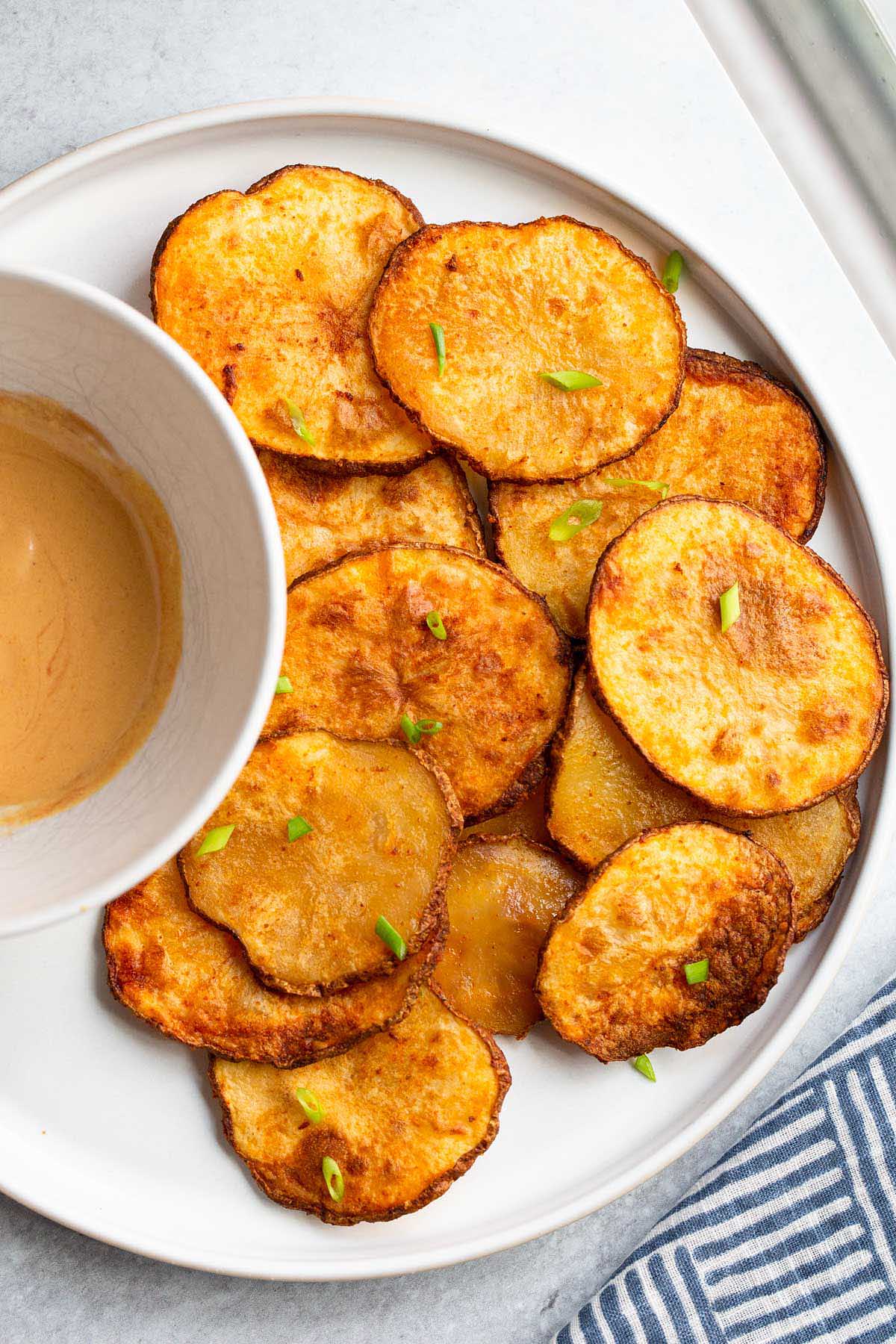 Air fryer potato slices with a dipping sauce.