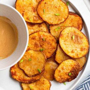 Air fryer potato slices with a dipping sauce.