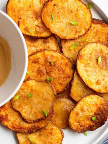 Air fryer potato slices with a dipping sauce.