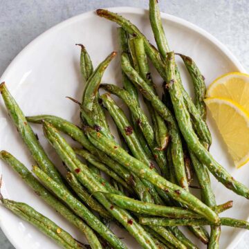 Air fryer spicy green beans on a white plate