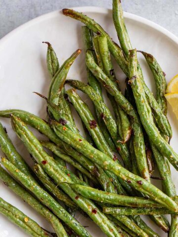 Air fryer spicy green beans on a white plate