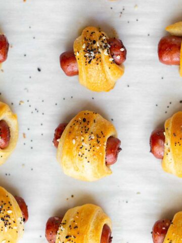 Everything bagel pigs in a blanket on a baking sheet