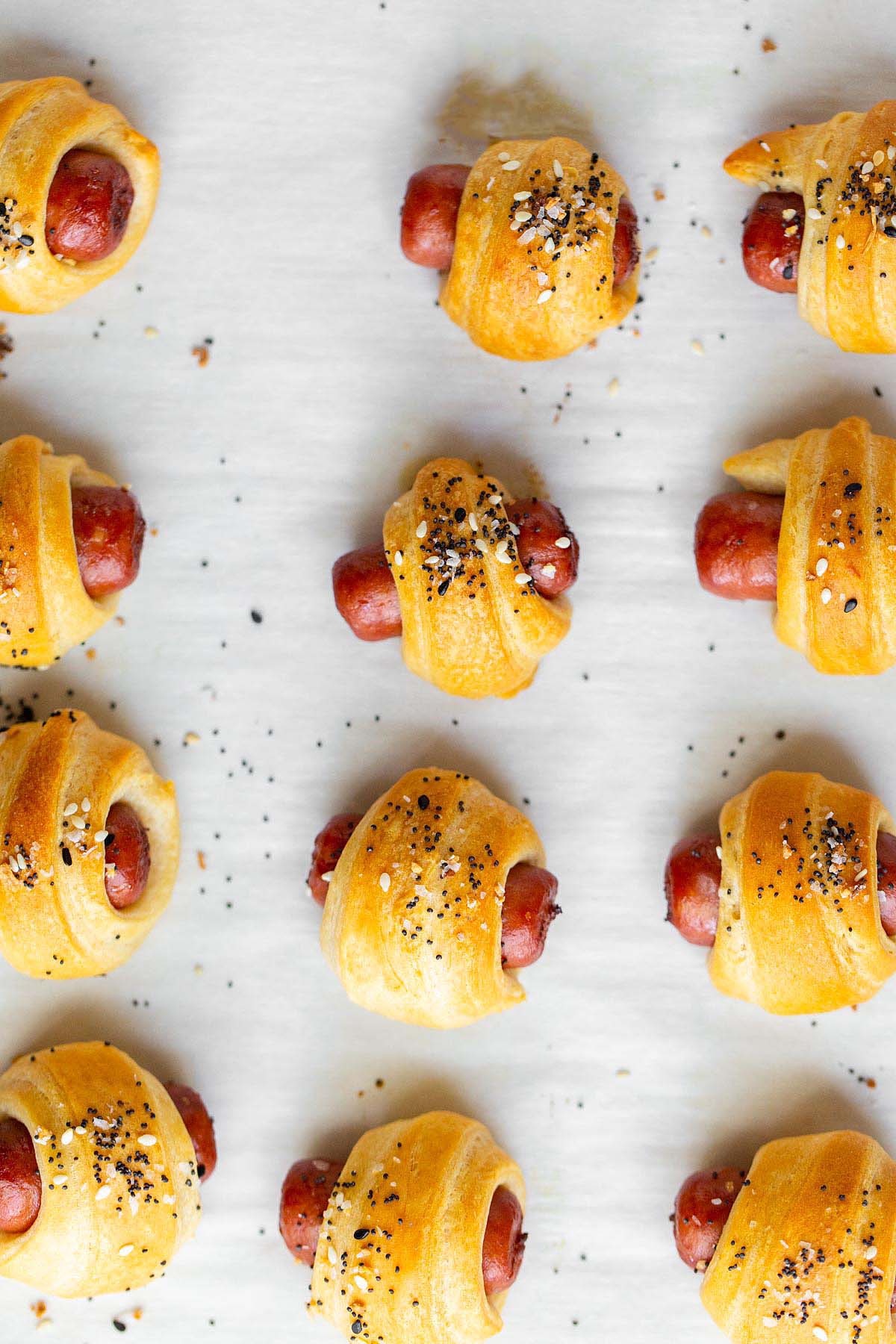 Everything bagel pigs in a blanket on a baking sheet