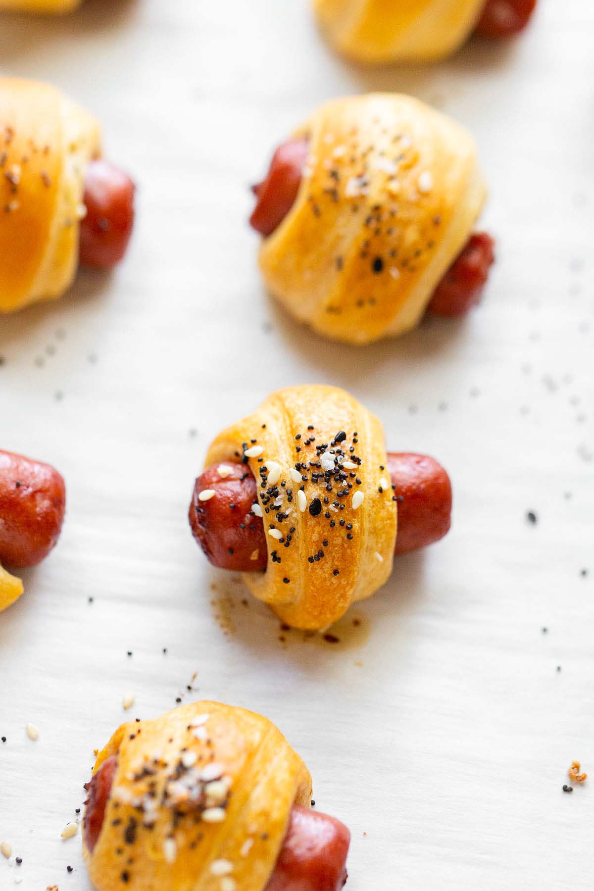 Everything bagel pigs in a blanket on a baking sheet