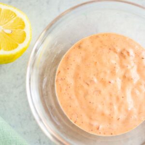 Harissa mayo in a bowl with a lemon on the side