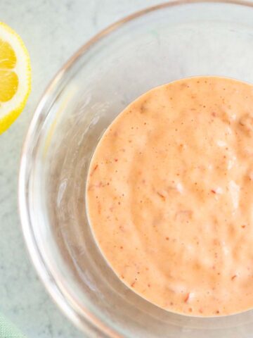 Harissa mayo in a bowl with a lemon on the side