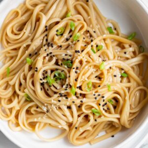 Miso butter noodles topped with sesame seeds and green onions