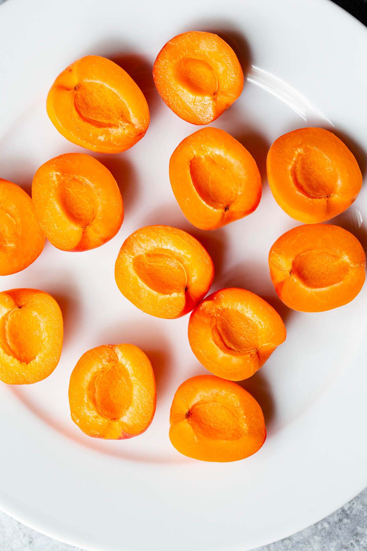 Apricots cut in half on a plate.