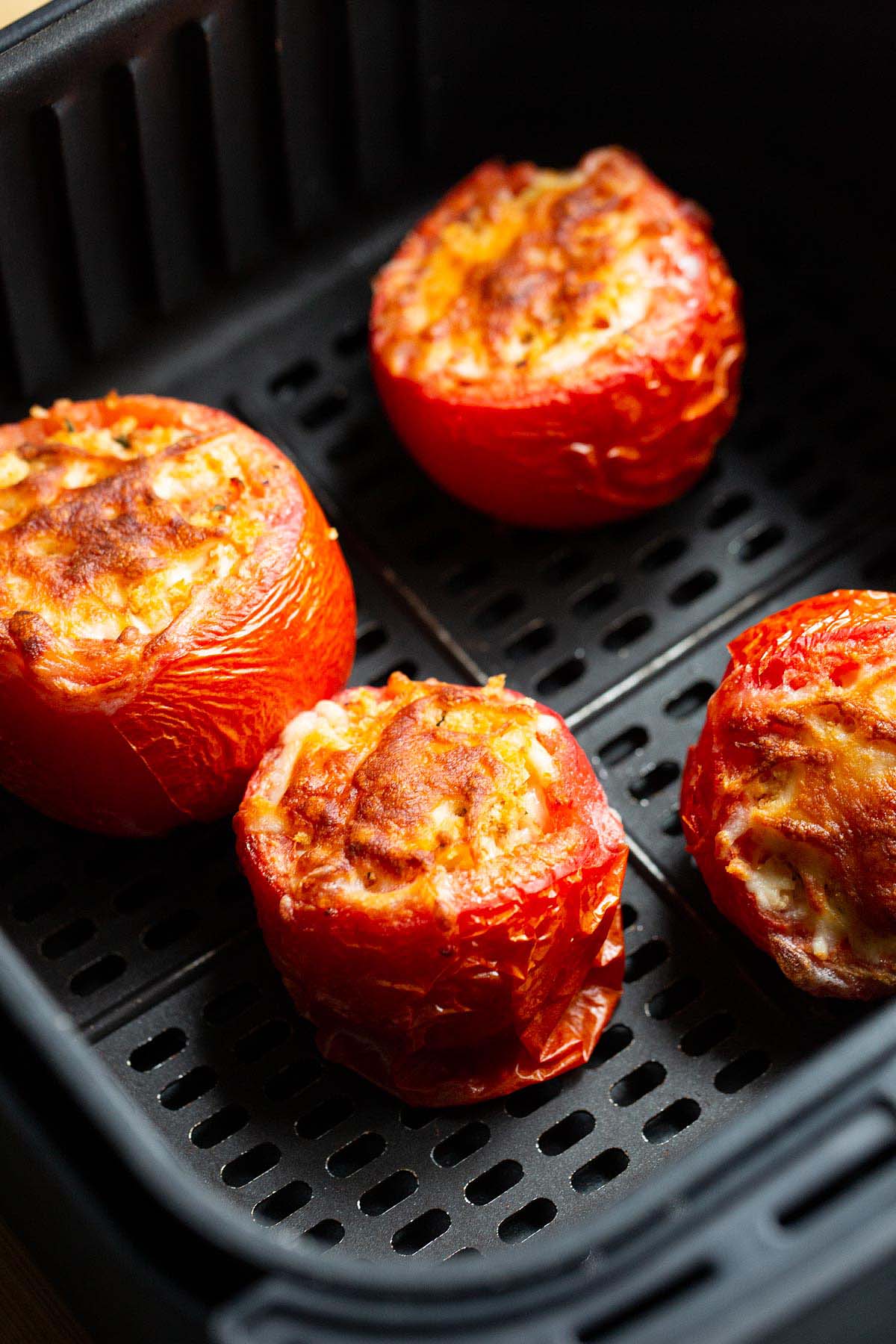 Air fryer tomatoes in air fryer basket.