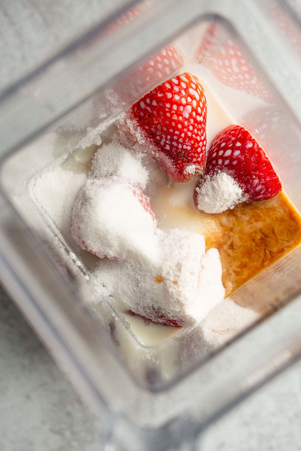 Strawberry cheesecake ice cream ingredients in a blender