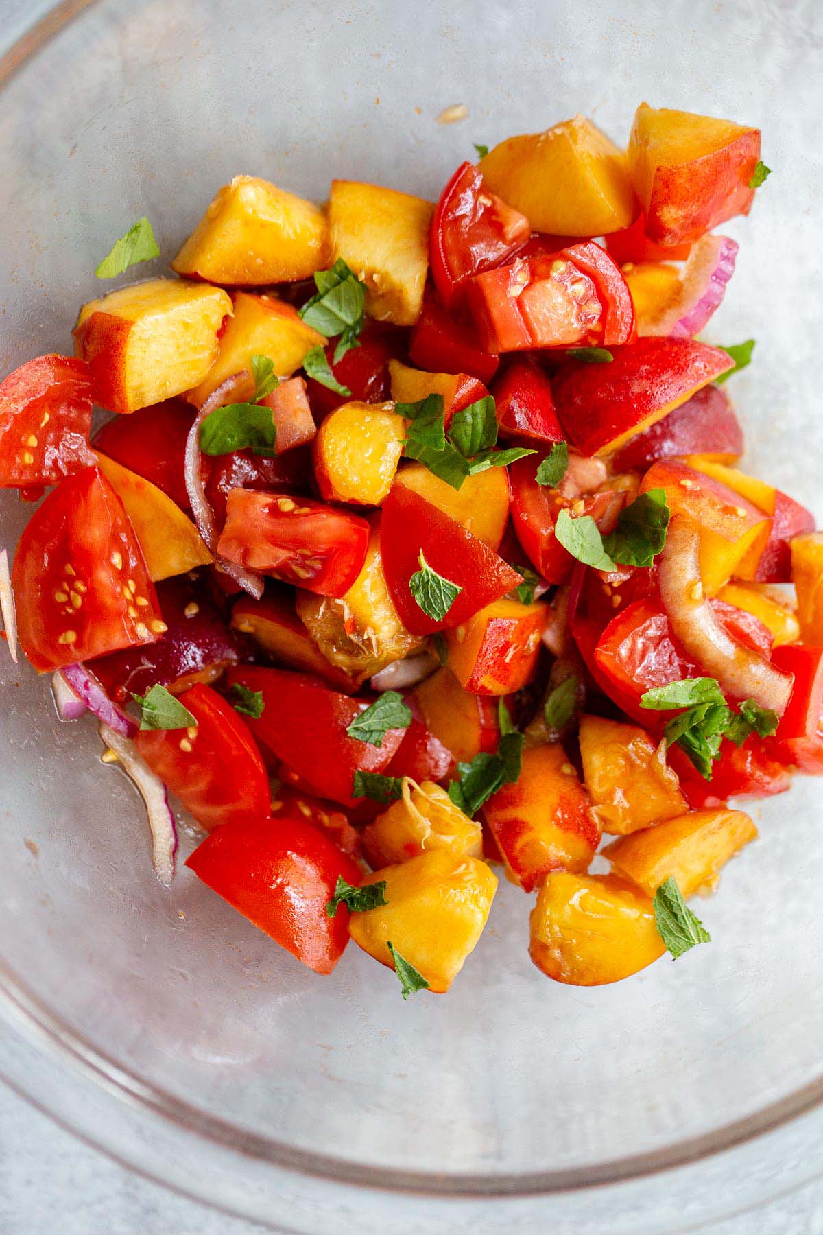 Adding basil and mint to the peach salad