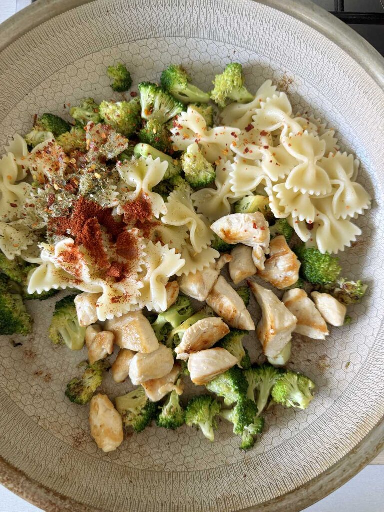 Adding pasta to the skillet.