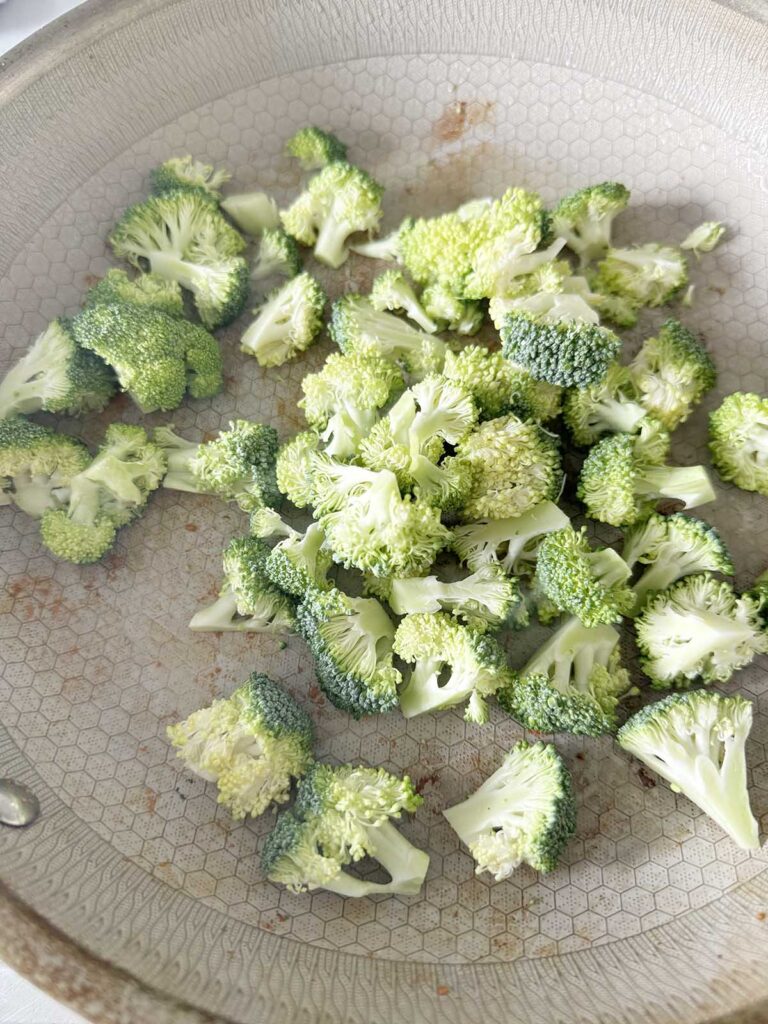 Broccoli florets in a skillet.