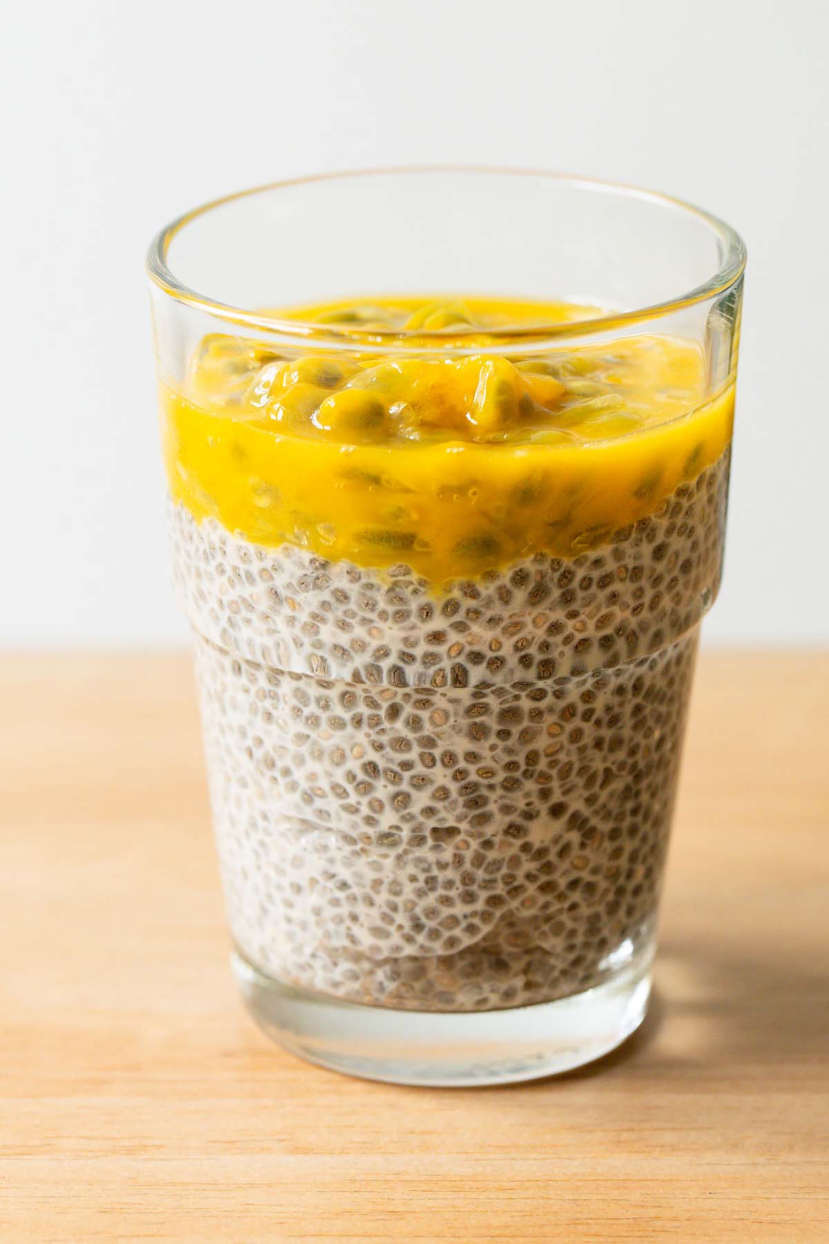Passionfruit chia pudding in a small clear glass.