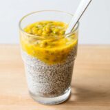 Passionfruit chia pudding in a cup with a spoon.