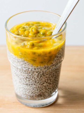Passionfruit chia pudding in a cup with a spoon.