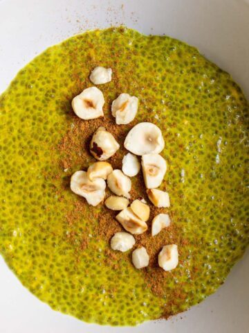 warm golden milk chia pudding topped with cinnamon and hazelnuts