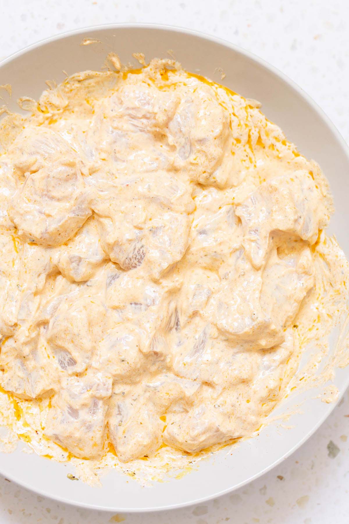 Chicken marinating in yogurt and seasonings