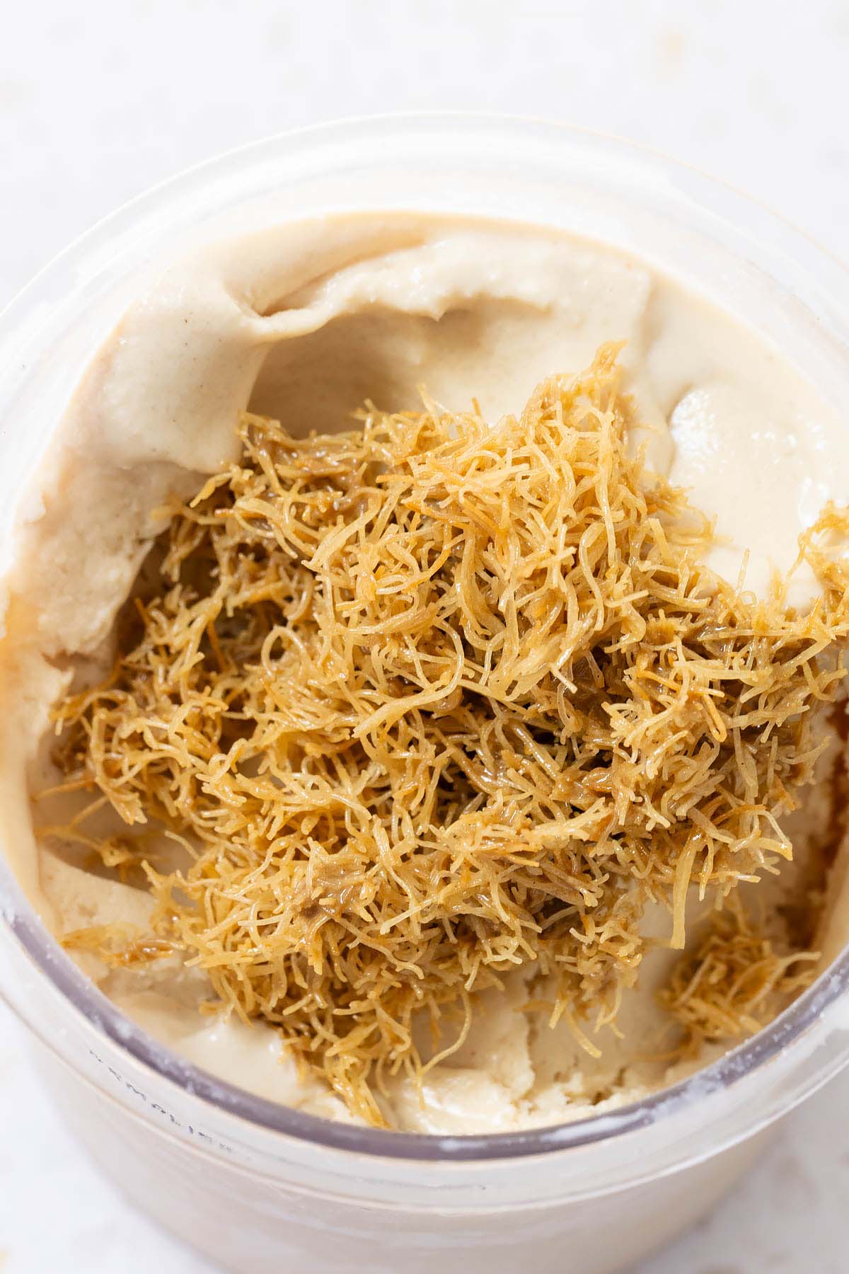 Adding crispy kadayif to pistachio ice cream