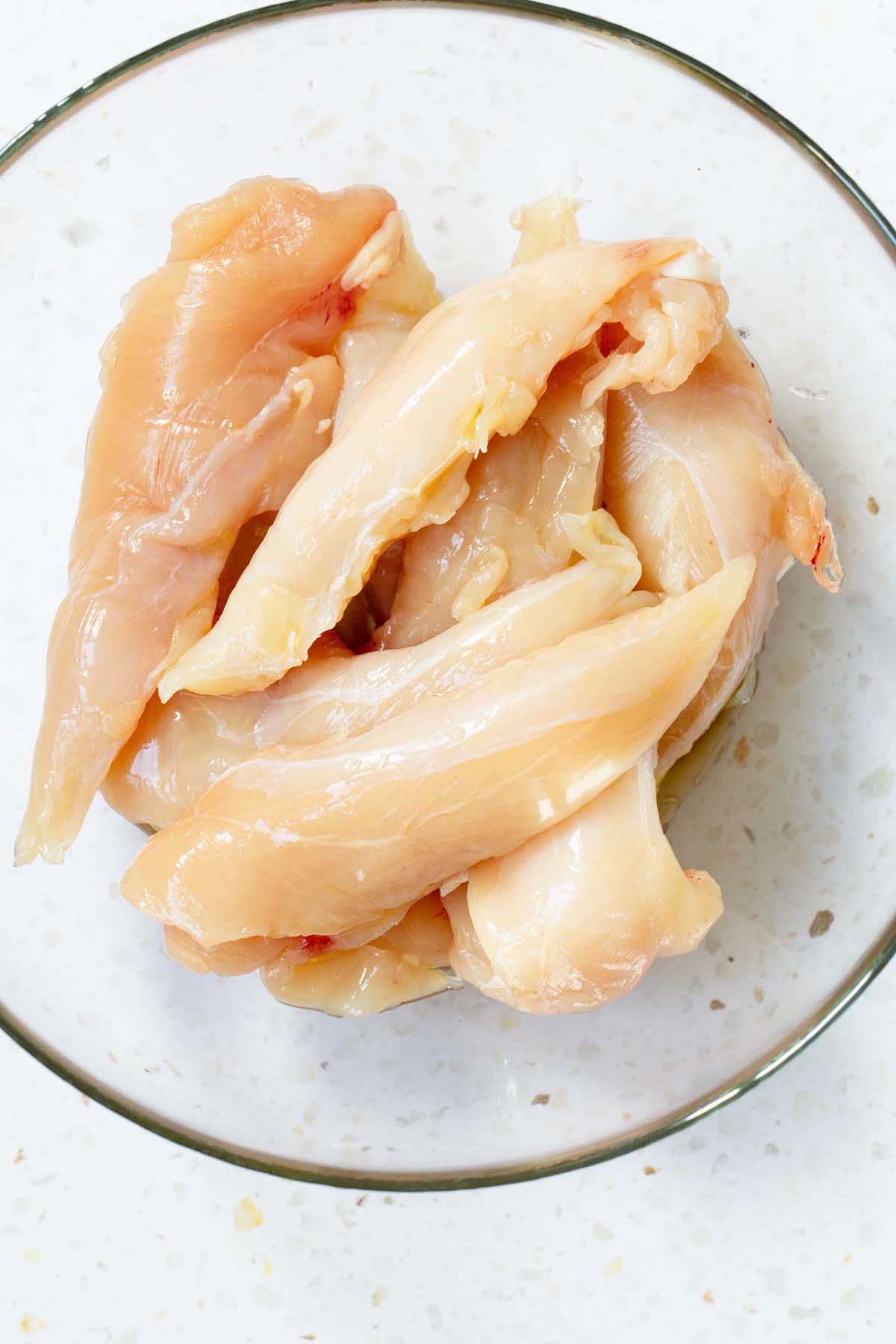 Raw chicken tenders in a bowl