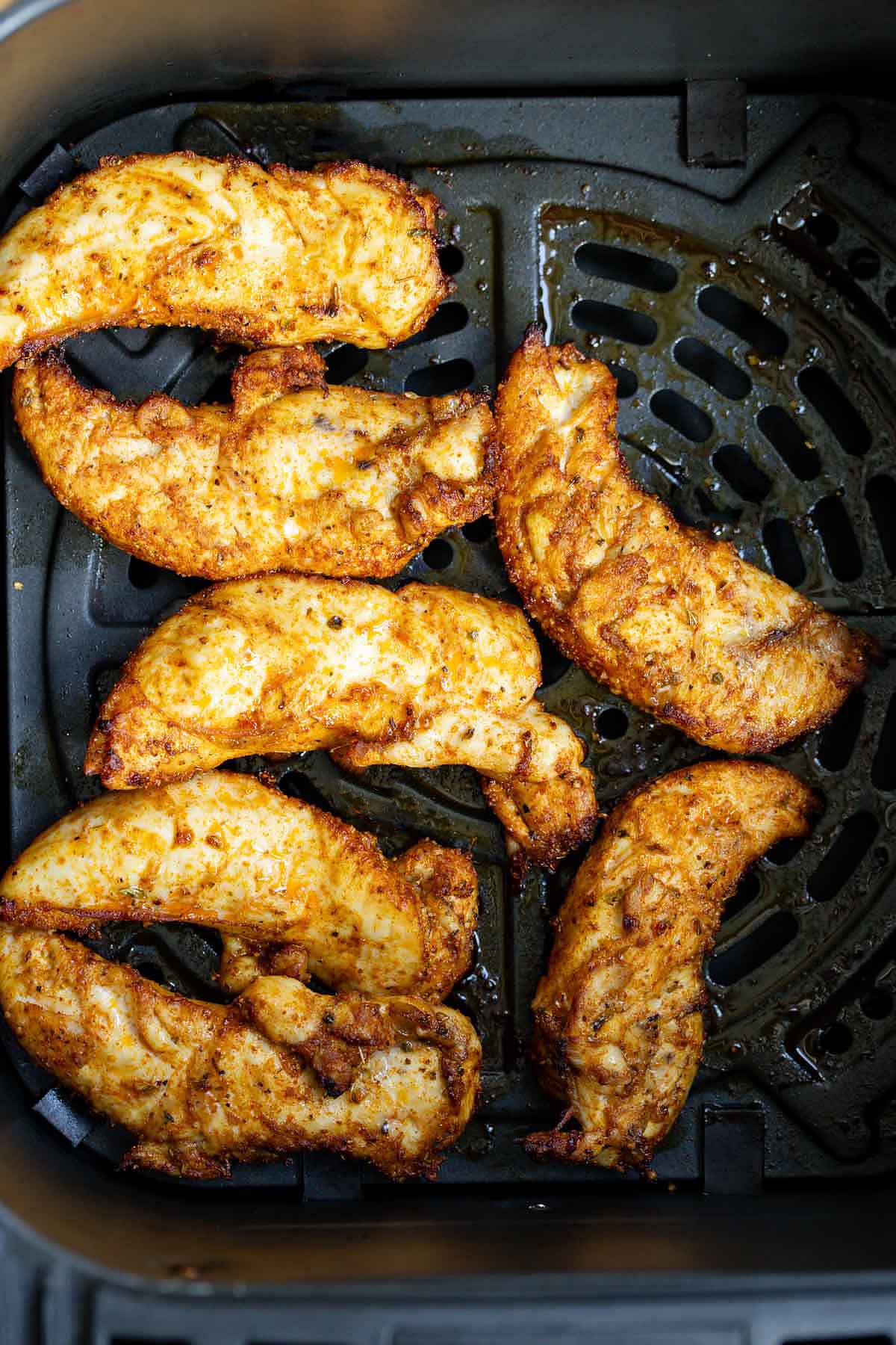 Cooked chicken tenders in air fryer basket
