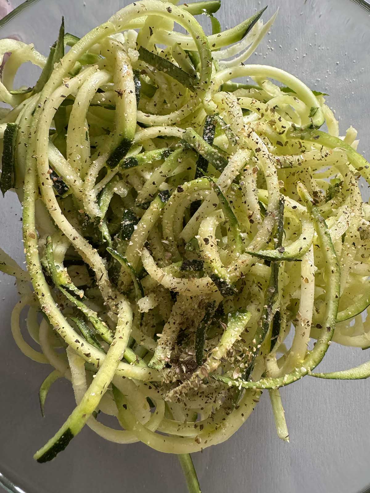 zoodles with oil and seasonings in a bowl