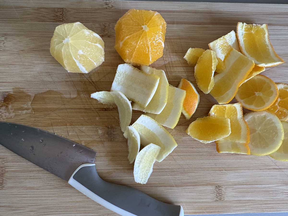 Slicing the peels off of lemon and orange