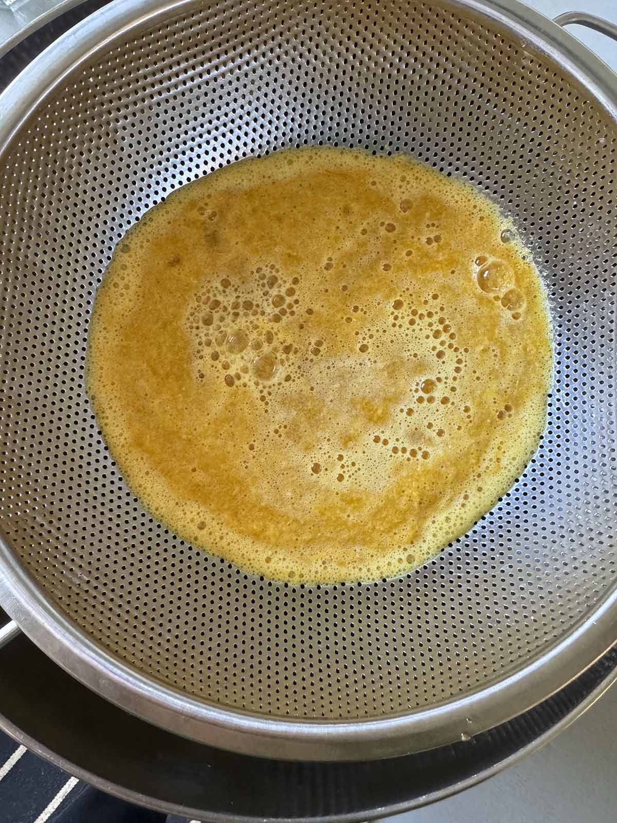 Straining turmeric shot mixture