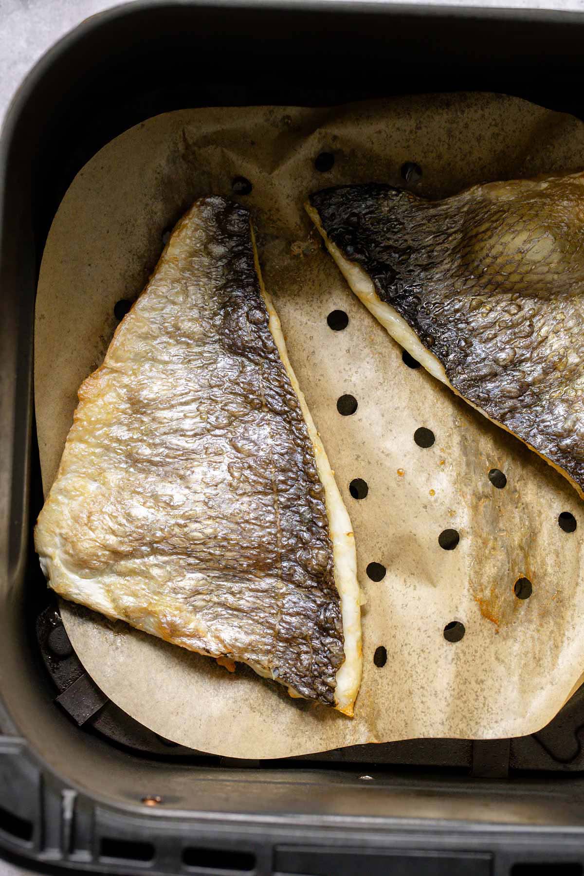 Cooked sea bream fillets in air fryer basket