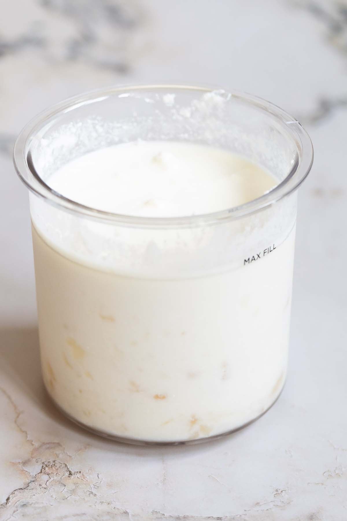 Lemon ricotta ice cream ingredients mixed together in Ninja Creami container