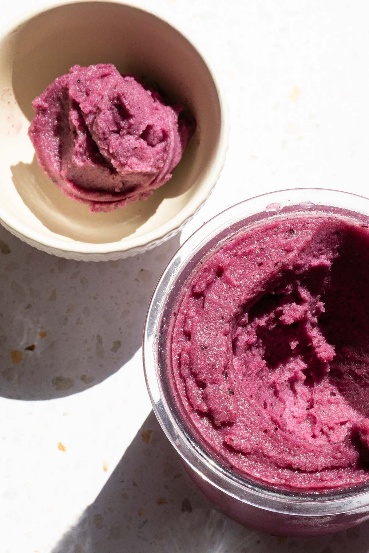 Ninja Creami grape sorbet with a scoop in a separate white bowl