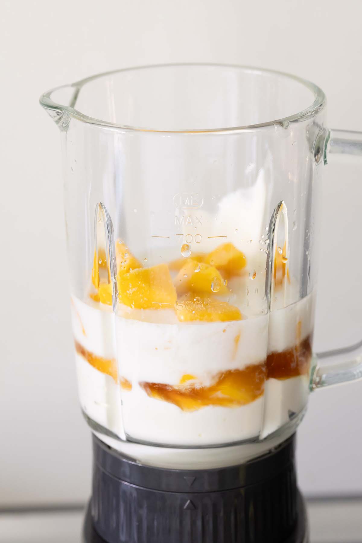 Ingredients for mango frozen yogurt in a blender