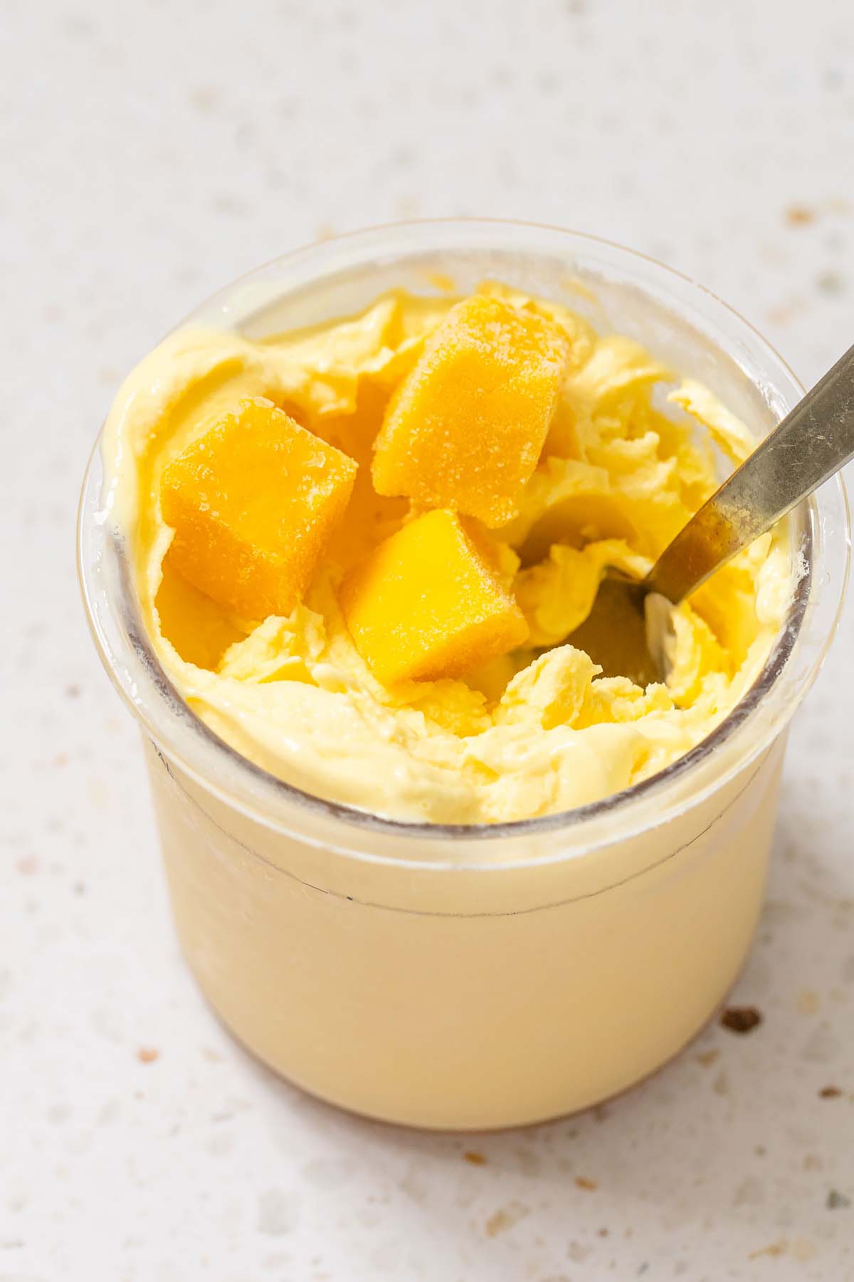 Ninja Creami mango frozen yogurt with mango pieces on top