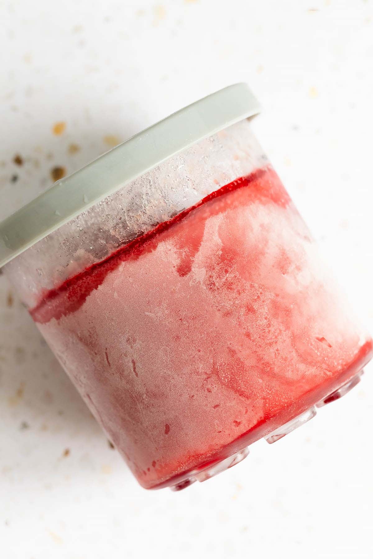 Frozen hibiscus sorbet in Ninja Creami container