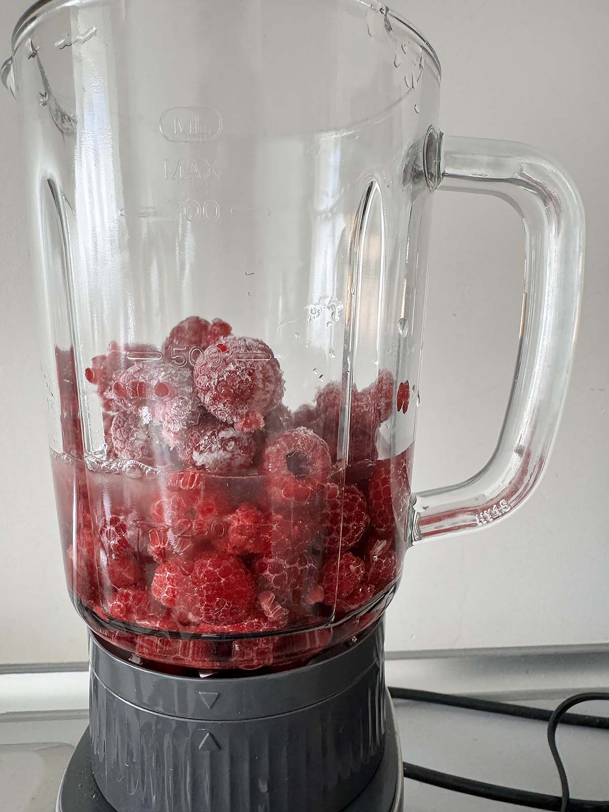 Raspberries and other ingredients in a blender