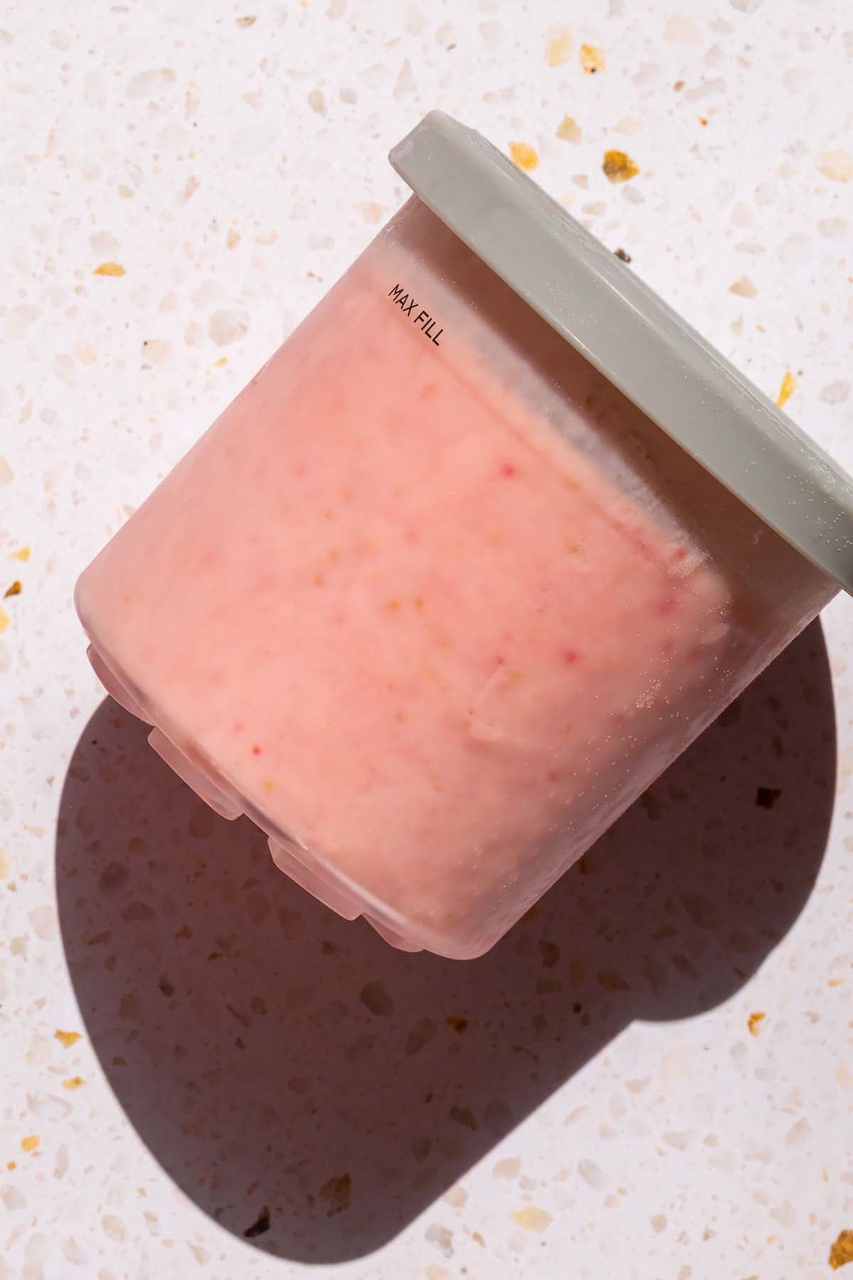 Frozen strawberry ricotta ice cream in Ninja Creami container