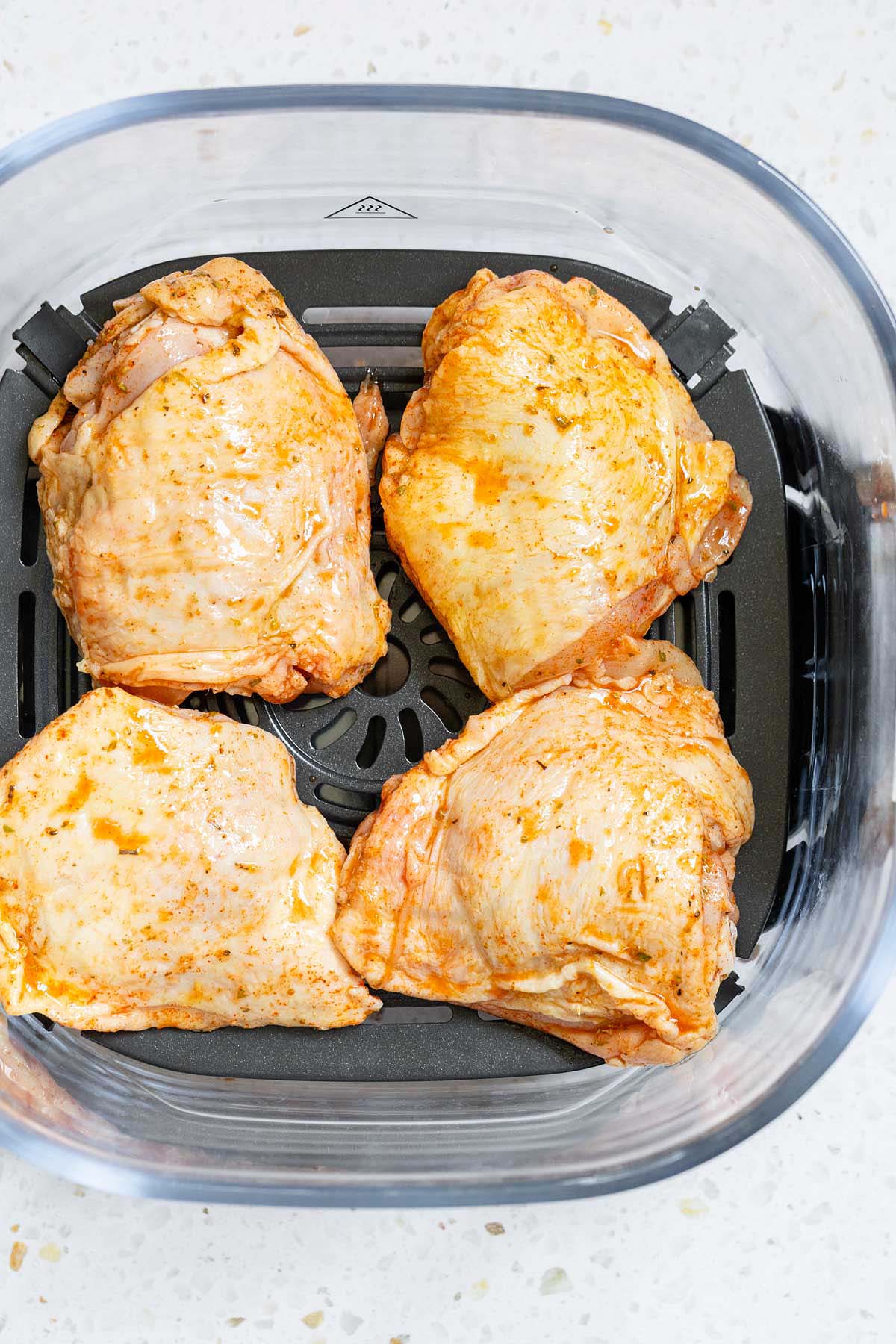 Uncooked chicken thighs in Ninja Crispi