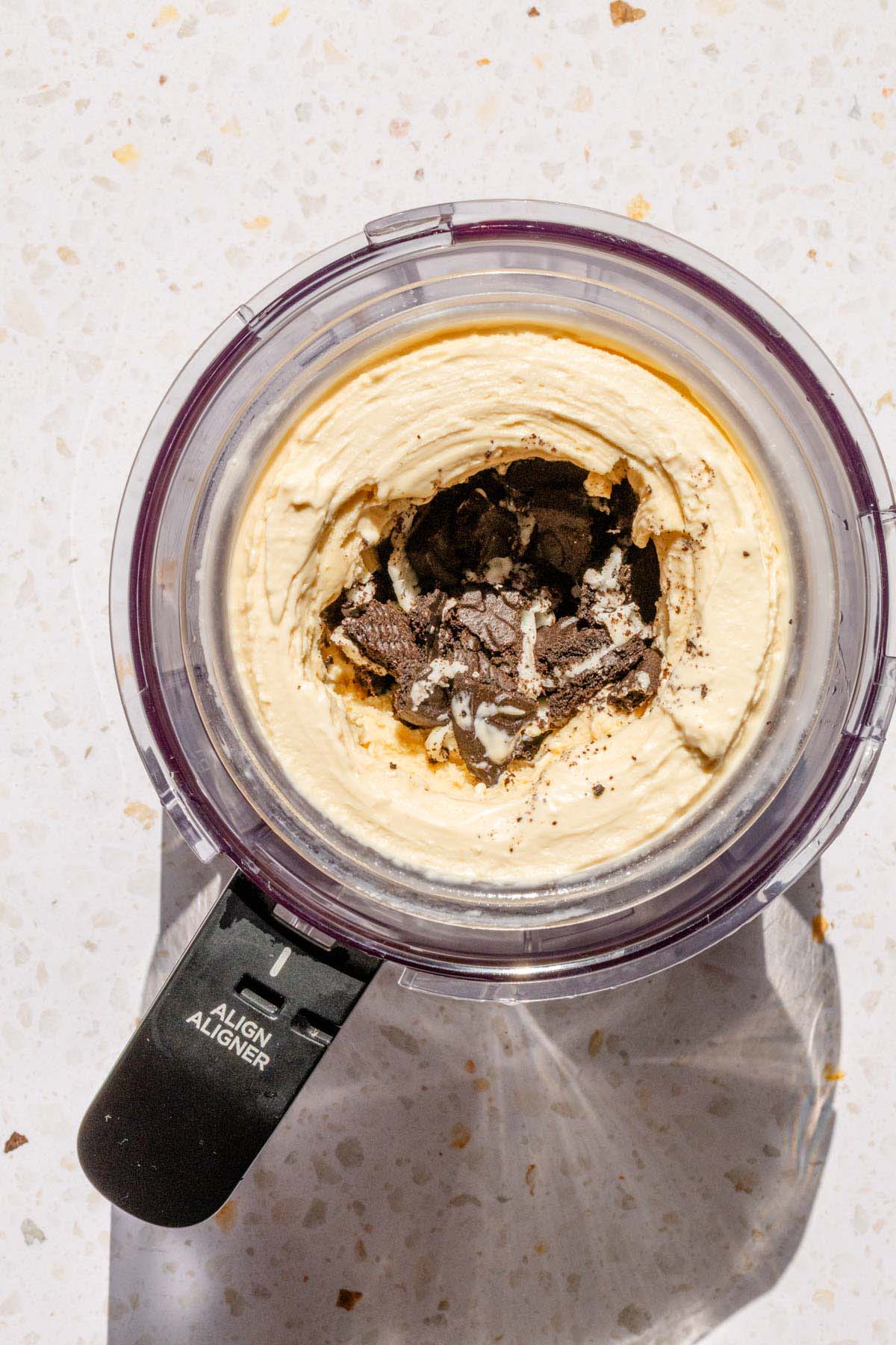 Adding cut Oreos to peanut butter ice cream