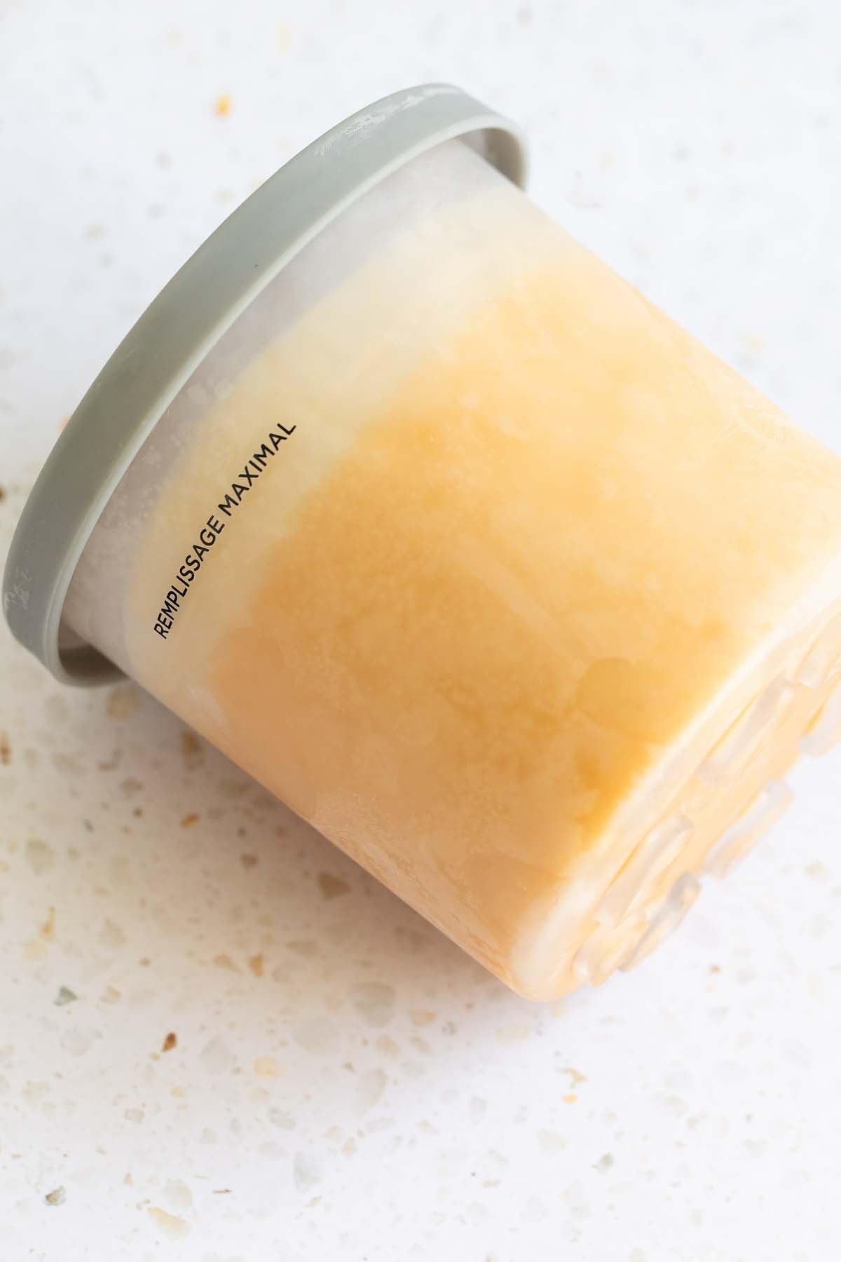 Frozen ice cream in Ninja Creami container with lid on