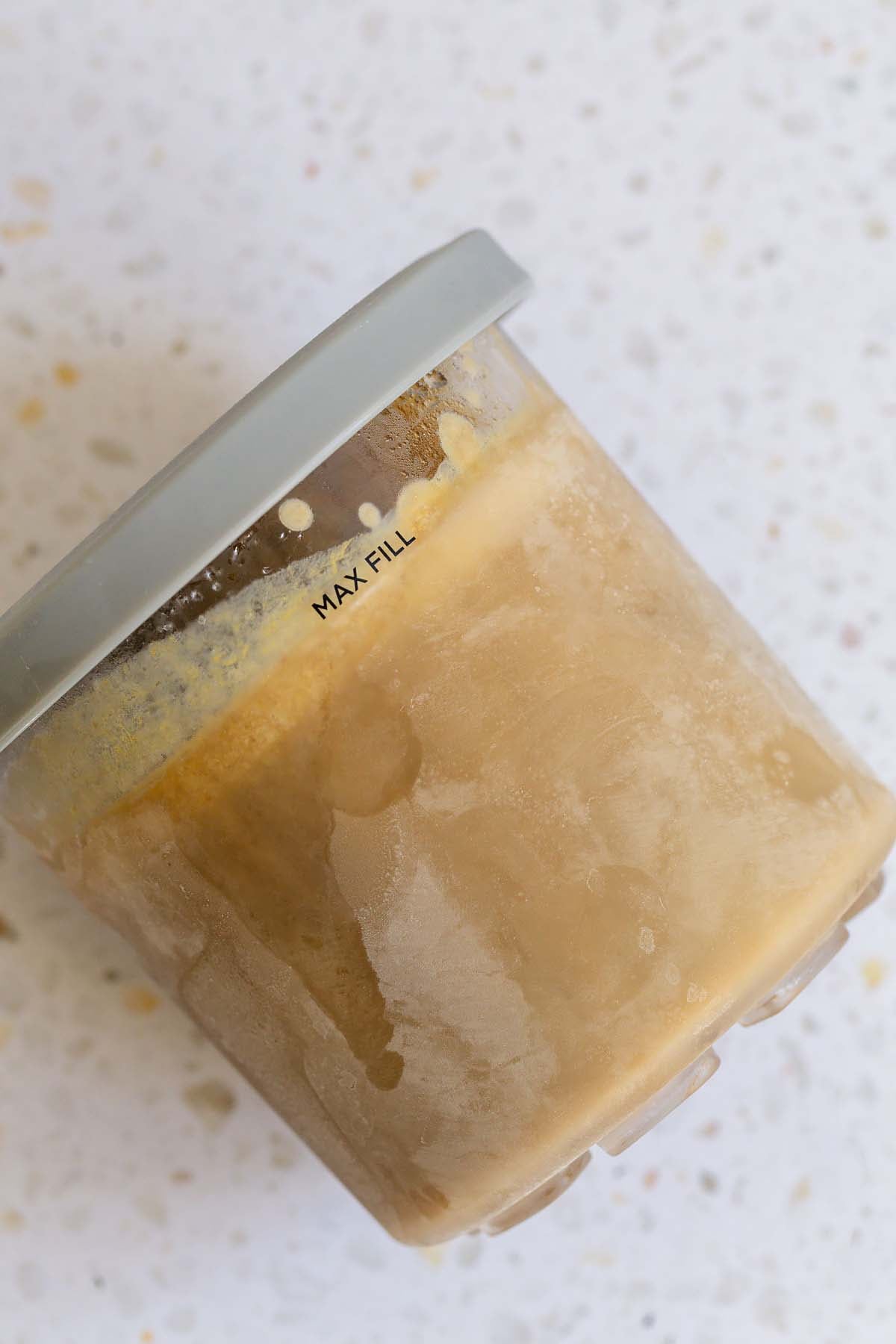 Frozen pumpkin ice cream in Ninja Creami container with lid on